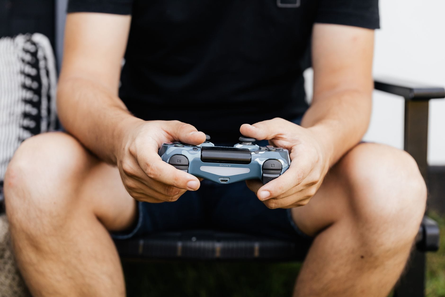 Dłonie trzymające bezprzewodowy kontroler do gier na konsoli PS4 Dłonie trzymające bezprzewodowy kontroler do gier na konsoli PS4