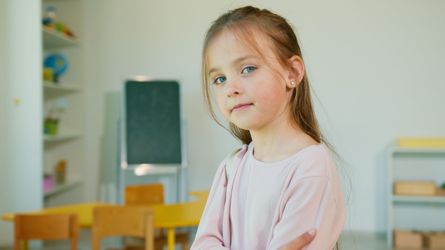 Uśmiechnięta dziewczynka w klasie na początku roku szkolnego Uśmiechnięta dziewczynka w klasie na początku roku szkolnego