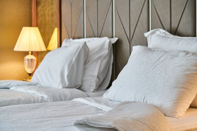 Łóżko z białą pościelą w przytulnym pokoju hotelowym